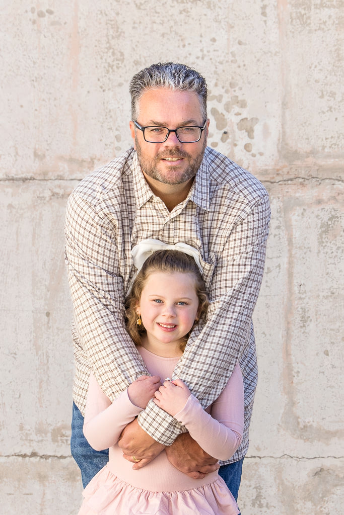 Dad hugging daughter during a family photo session at Mt Stromlo, Canberra