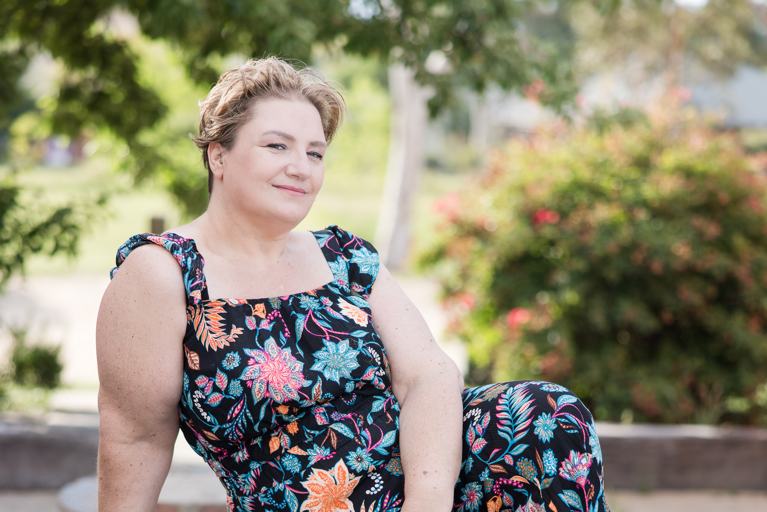 Oliver Street Photography - Create your Space with Shara. Woman wearing a colourful jumpsuit leaning to one side and looking at the camera.