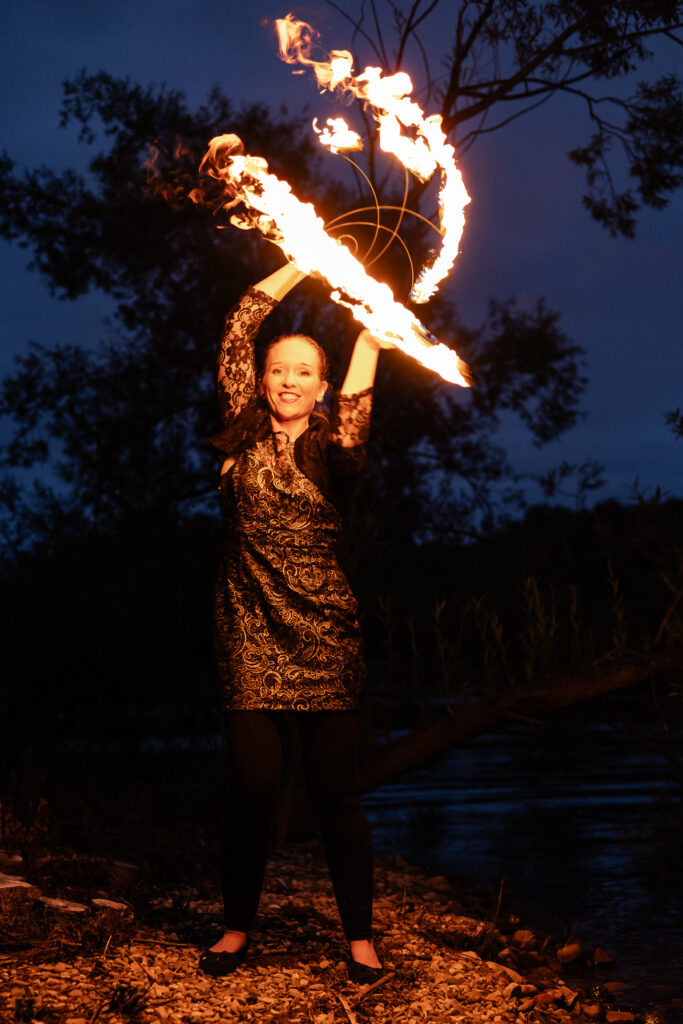 Photograph of a woman dancing and fire twirling above her head