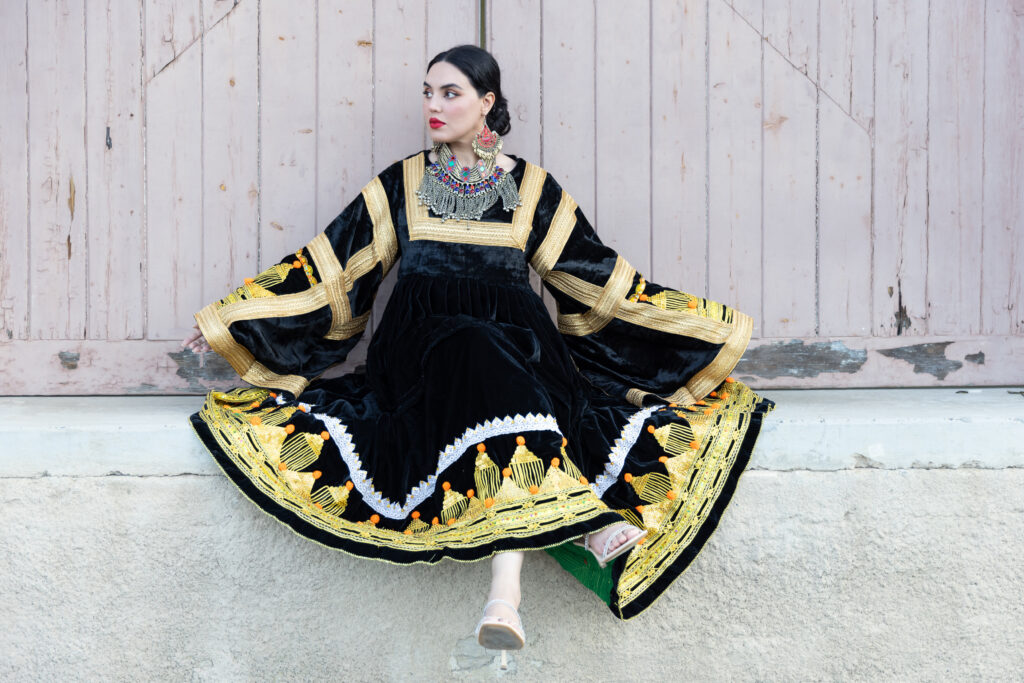 Woman wearing Afghan-inspired RAAZ brand dress, leaning against a door at Kingston, Canberra