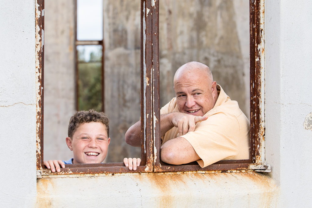 Dad and son looking out the window of the ruined Mt Stromlo Observatory during a family photo session