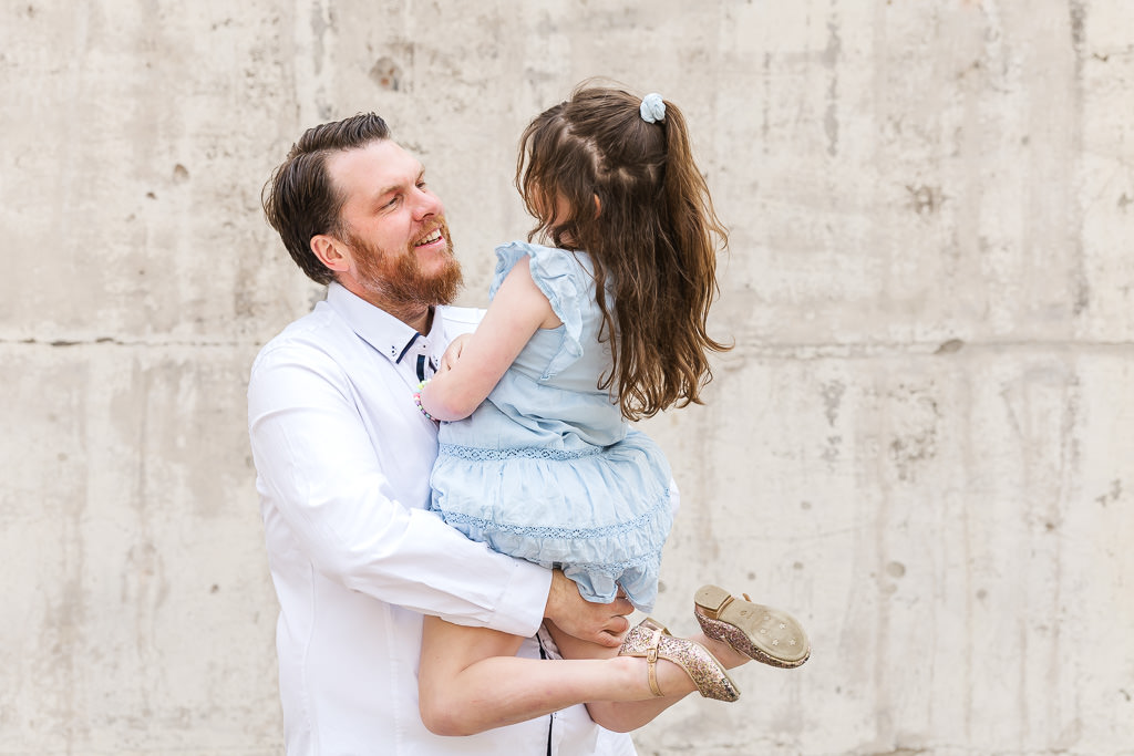 Dad picking up daughter during a family photo session at Mt Stromlo, Canberra