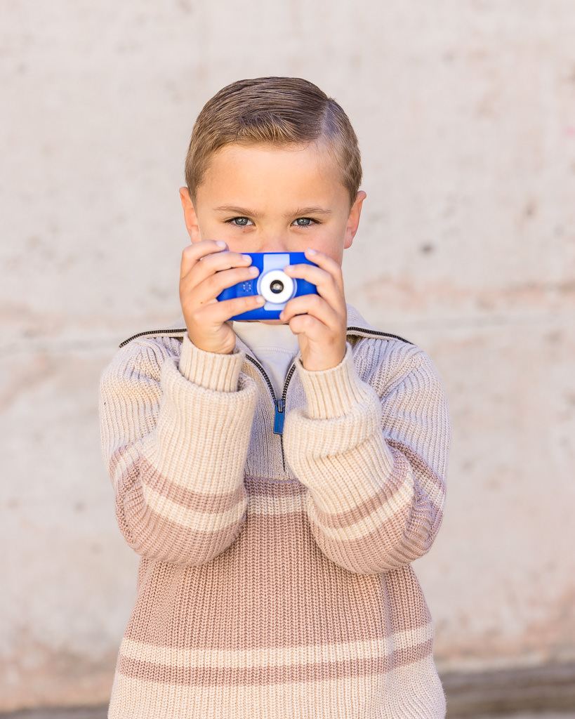 Young boy holding blue camera during a photo session at Mt Stromlo Observatory
